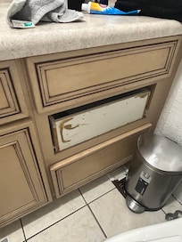 Bathroom sink cabinet and missing drawer panel.