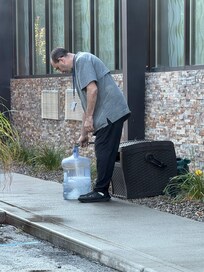 Staff filling water bubblers with hose water