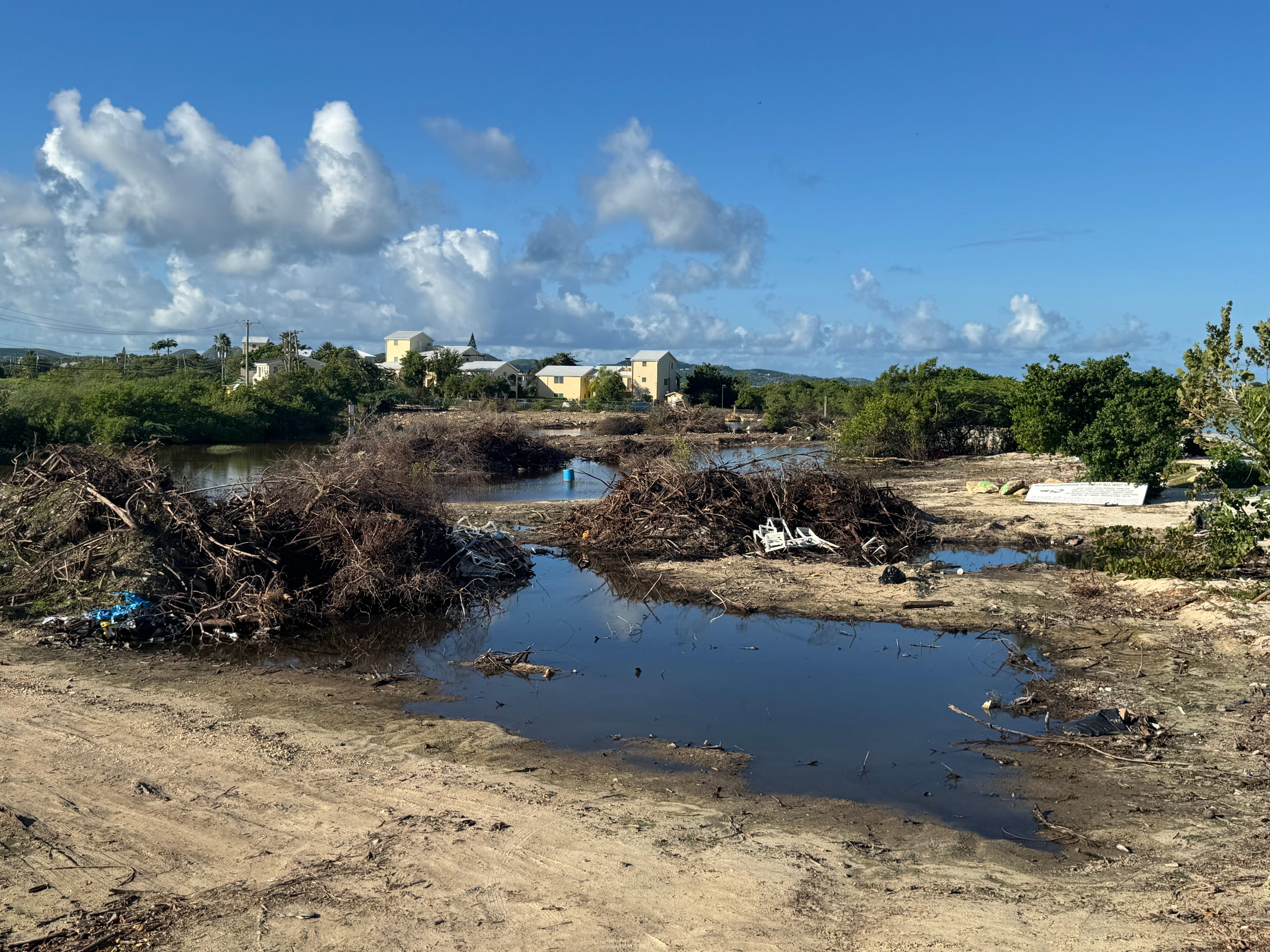 A waste land next to property with dumped rubbish. 