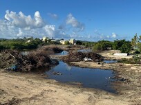 A waste land next to property with dumped rubbish.