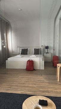 Het tweepersoonsbed met een glazen wand ervoor.