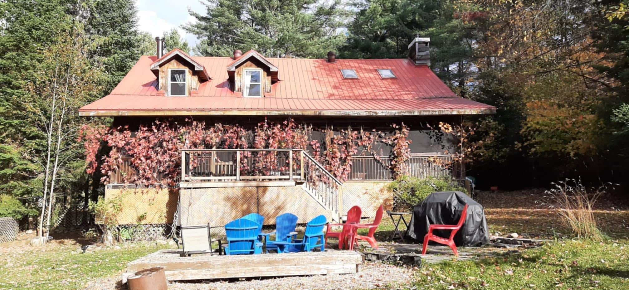 The view of the screened back porch with fire pit surrounded by chairs
