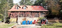 The view of the screened back porch with fire pit surrounded by chairs