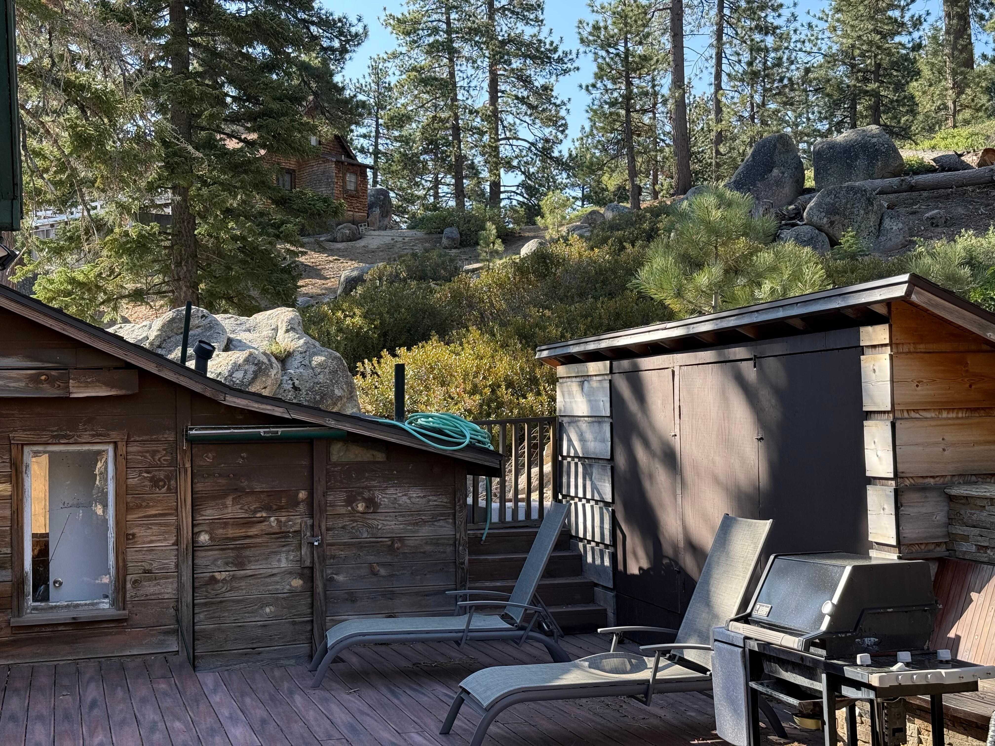 Back deck shown with non functional bbq and hose not put away