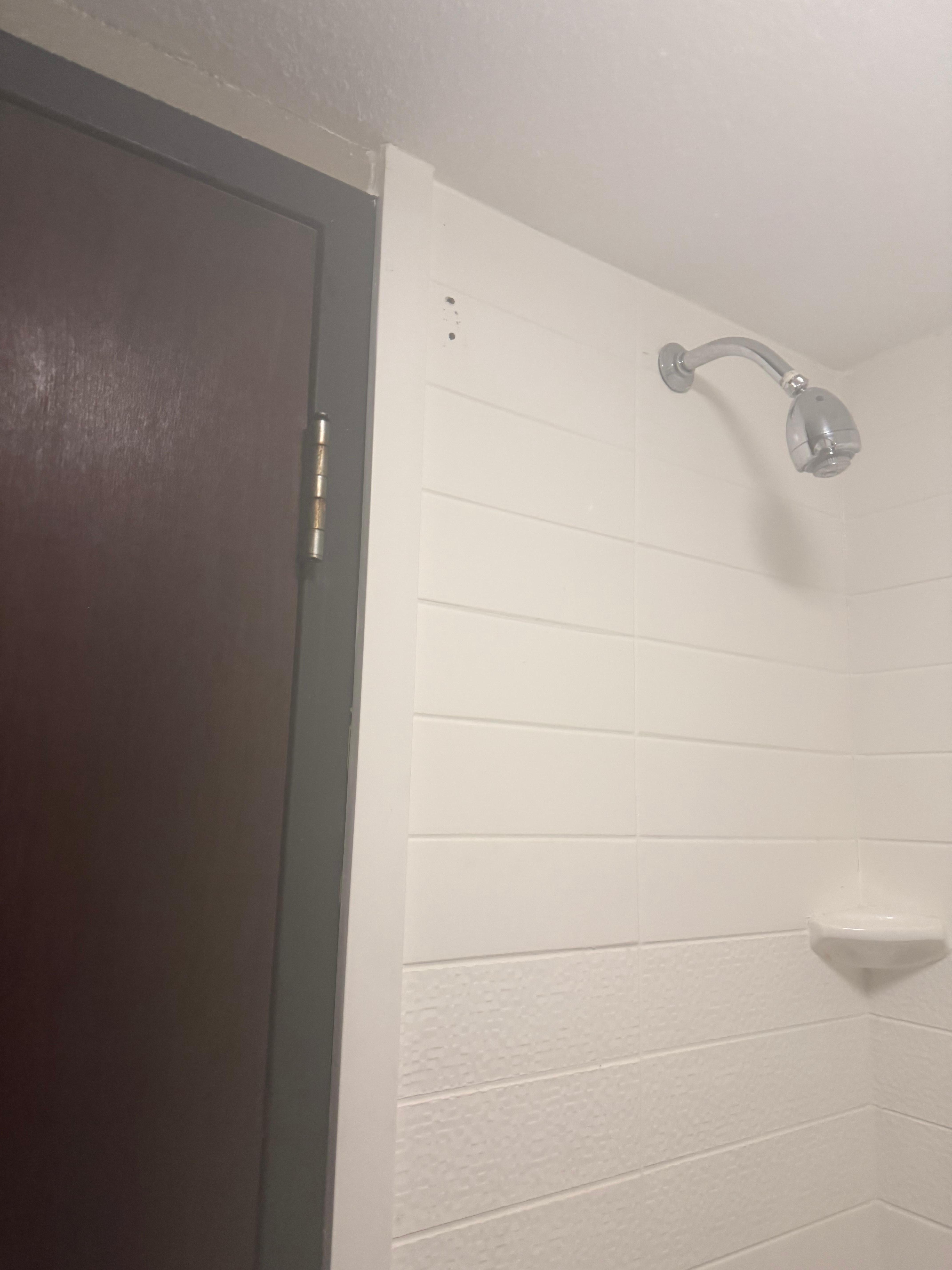 Visible holes from shower curtain was pulled from wall