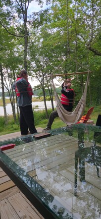 Owner provides life jackets, paddles, paddle boards, and has a full dining table and couch on the outdoor patio under an overhang.
