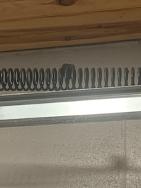 Here's a wasp nest in the spring of the garage door preventing opening of the door