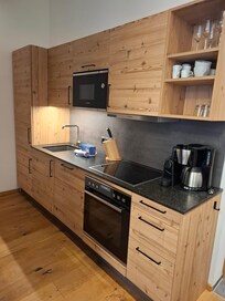 Küche mit Spülmaschine, Mikrowelle und Backofen