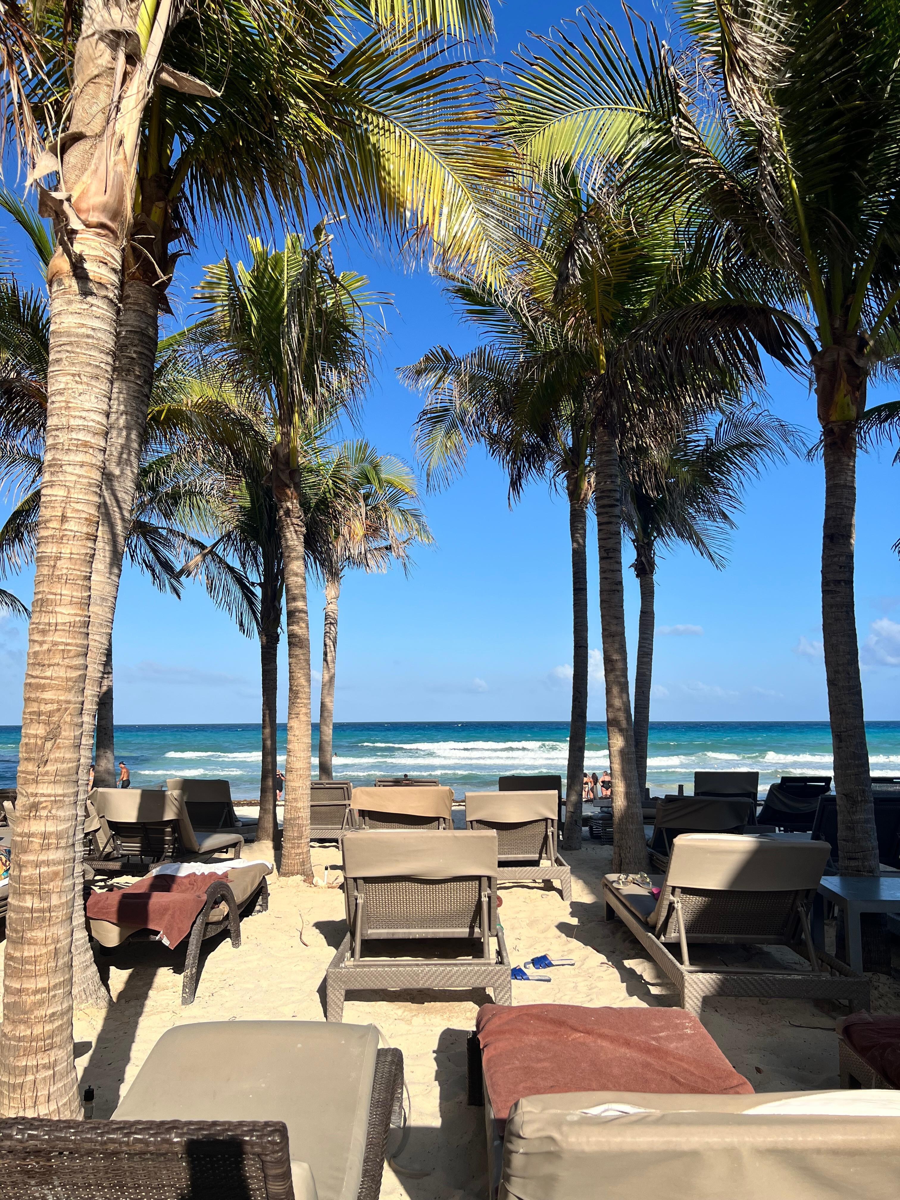 Muitas cadeiras e mesas na beira da praia 