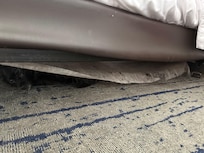 The felt of the box spring hanging down.