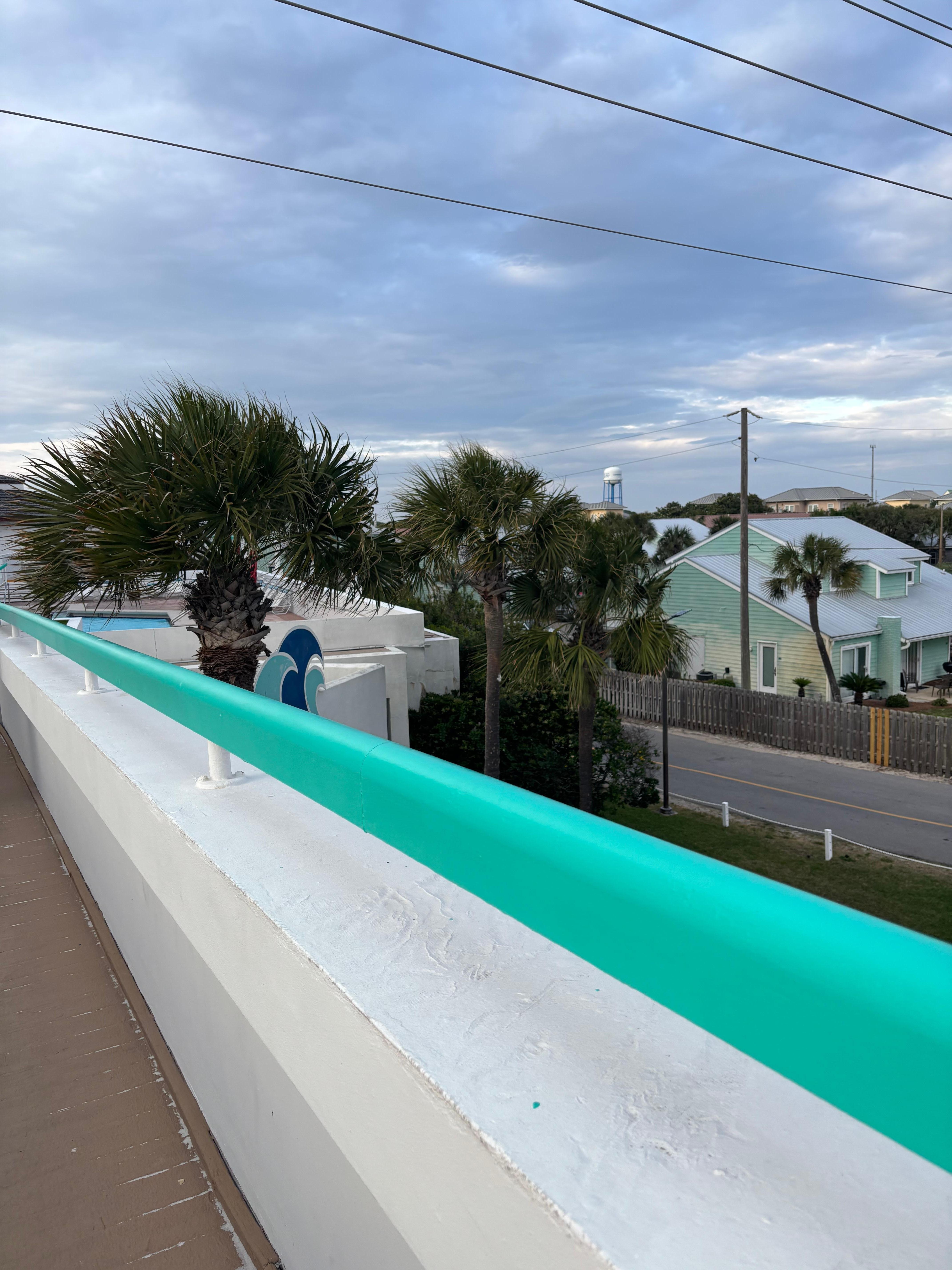 The bridge that connects from resort to beach, palm trees. 
