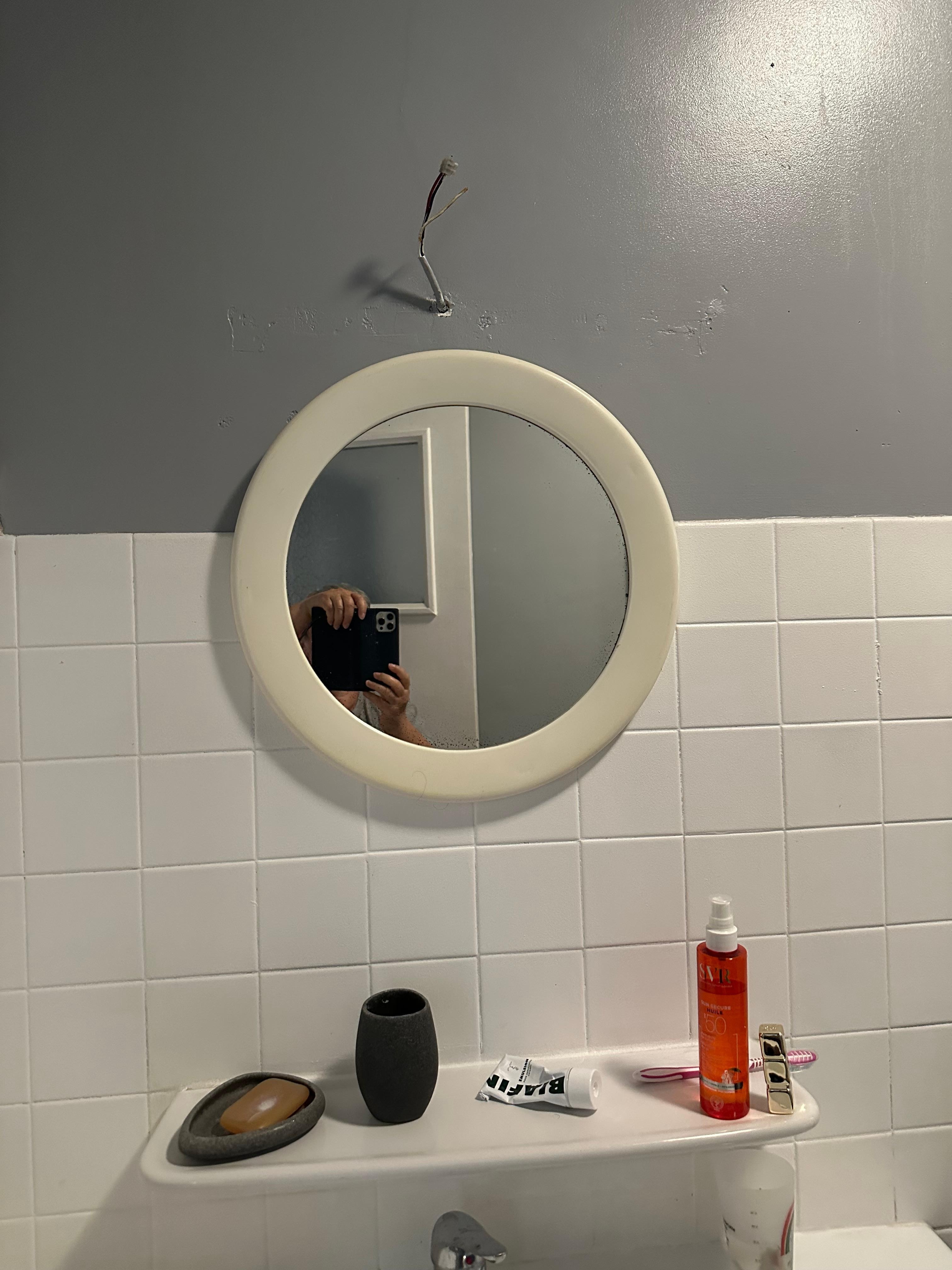 câble électrique à nu au dessus du miroir de la salle de bain