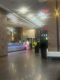 The main lobby with a modern check-in counter. Lighting is bright and the space feels open, with a mix of brick walls and sleek finishes.