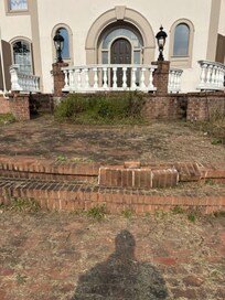 front steps falling apart and overgrown