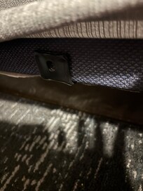 Under the cover on the side of the bed