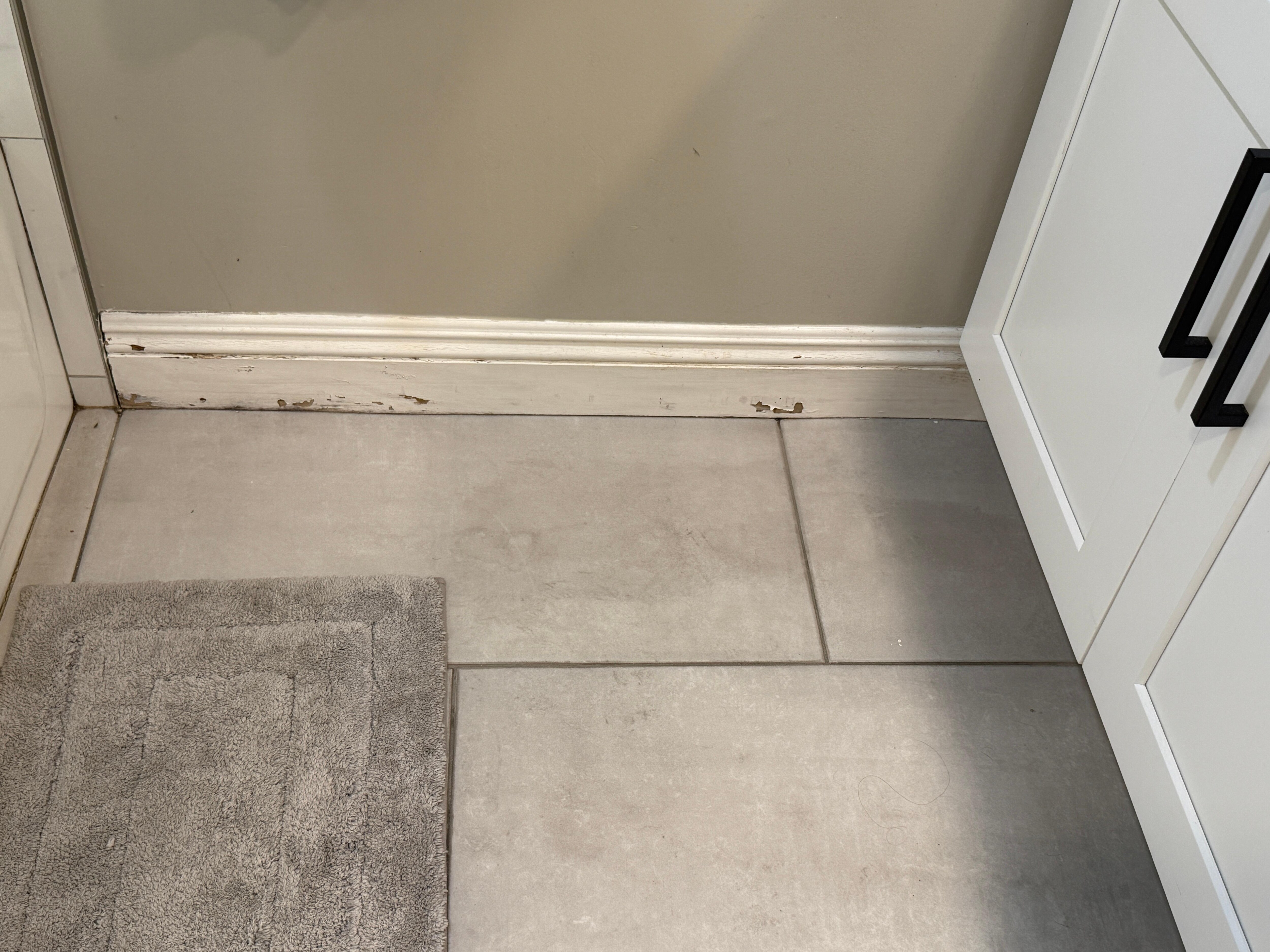 peeled and dirty baseboards in bathroom