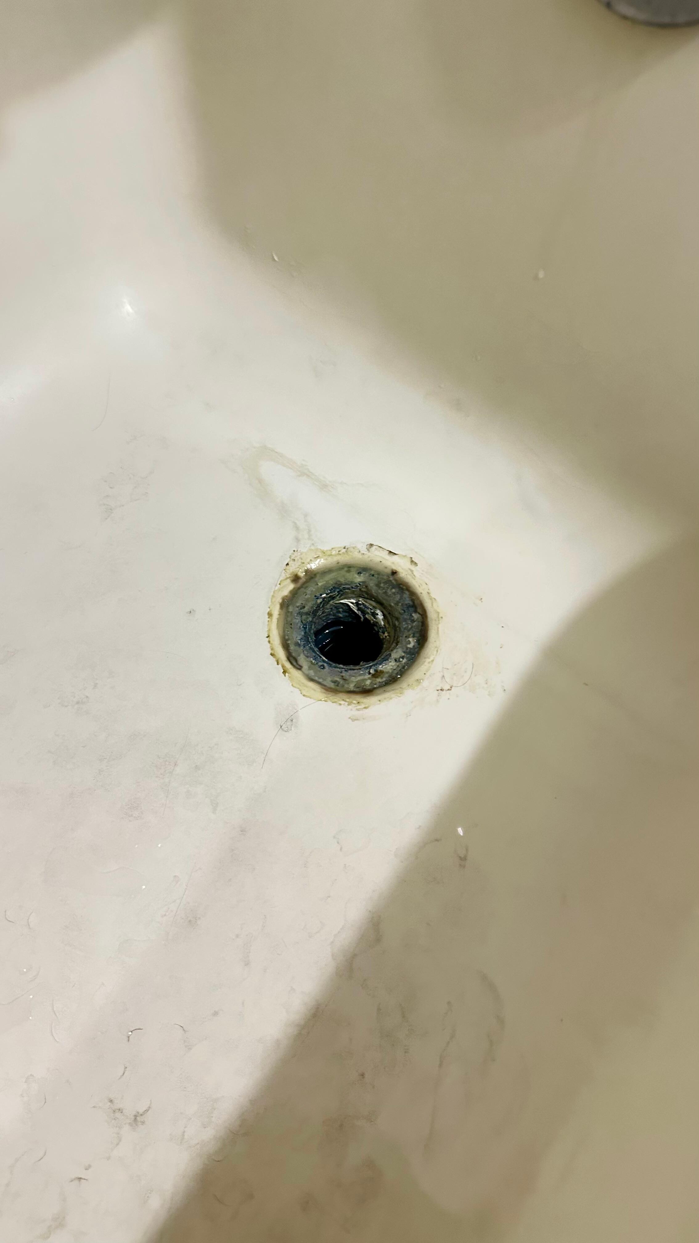 Rusty, stained tub with no drain cover – shows neglect and hygiene risk