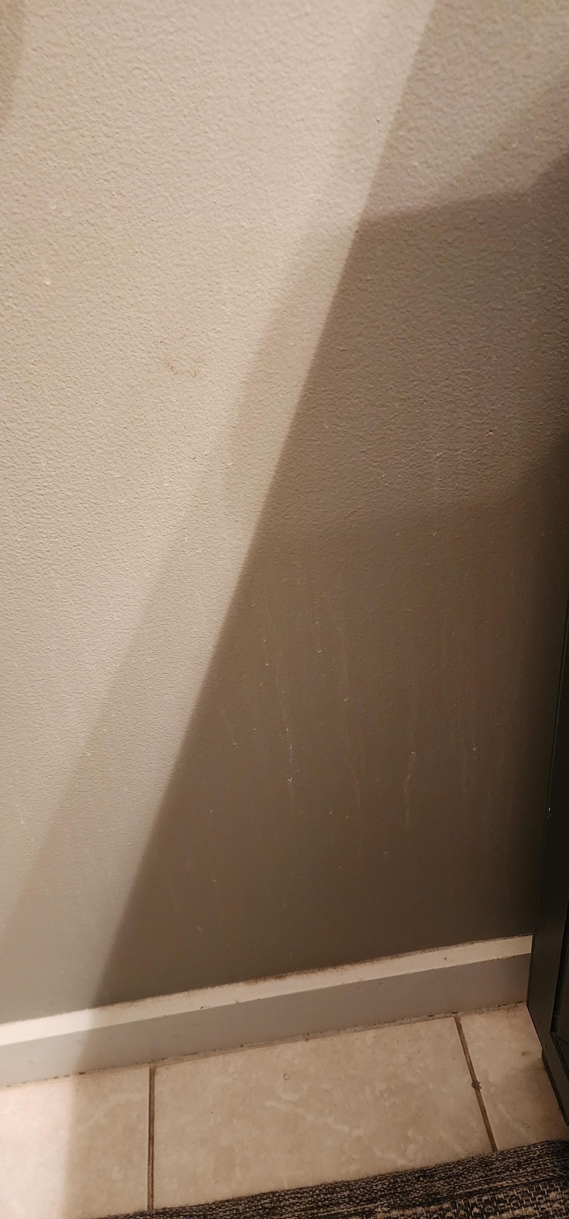 Toothpaste/water/dirt on walls by bathroom sink