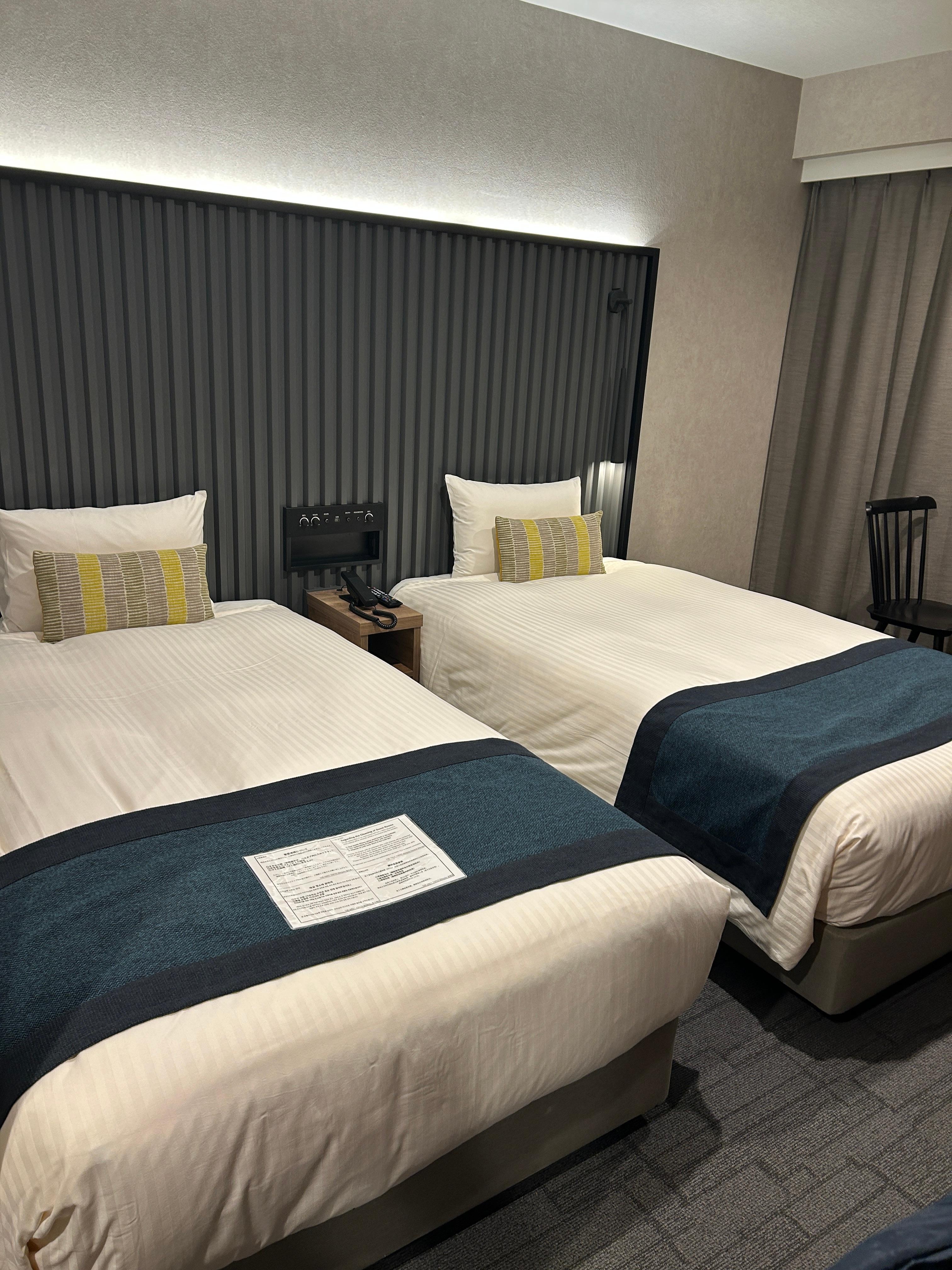 Two twin beds with light switch control panel in between