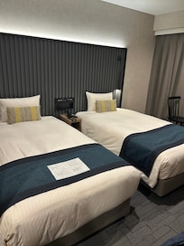 Two twin beds with light switch control panel in between