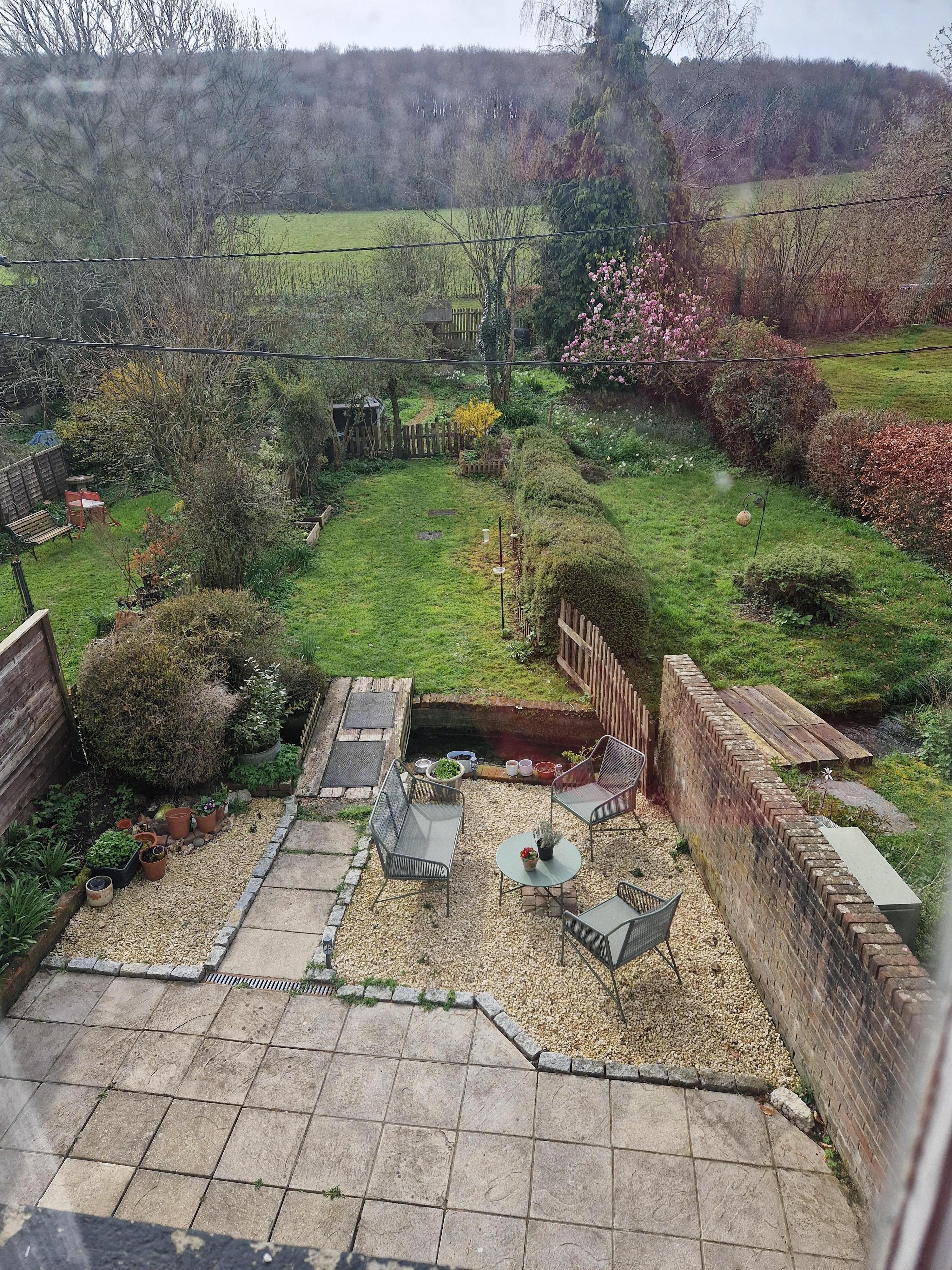 Back garden with little bridge over the river. 