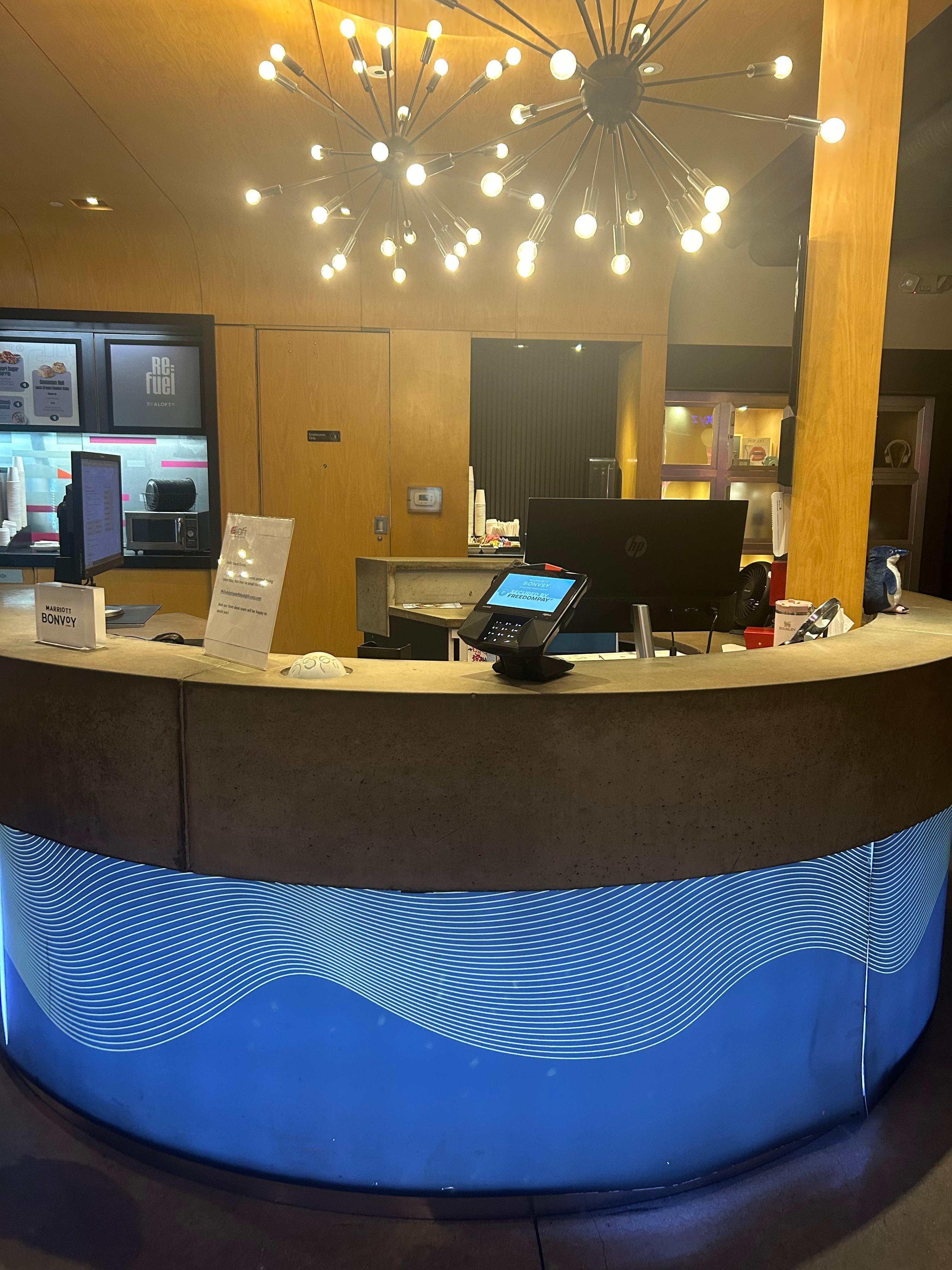 The front desk with no hotel staff and nobody in sight. 