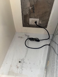 Mold behind refrigerator and hole in wall.