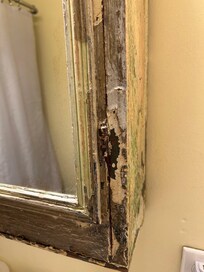 A hanging mirror- potentially dangerous with cracked exposed wood.