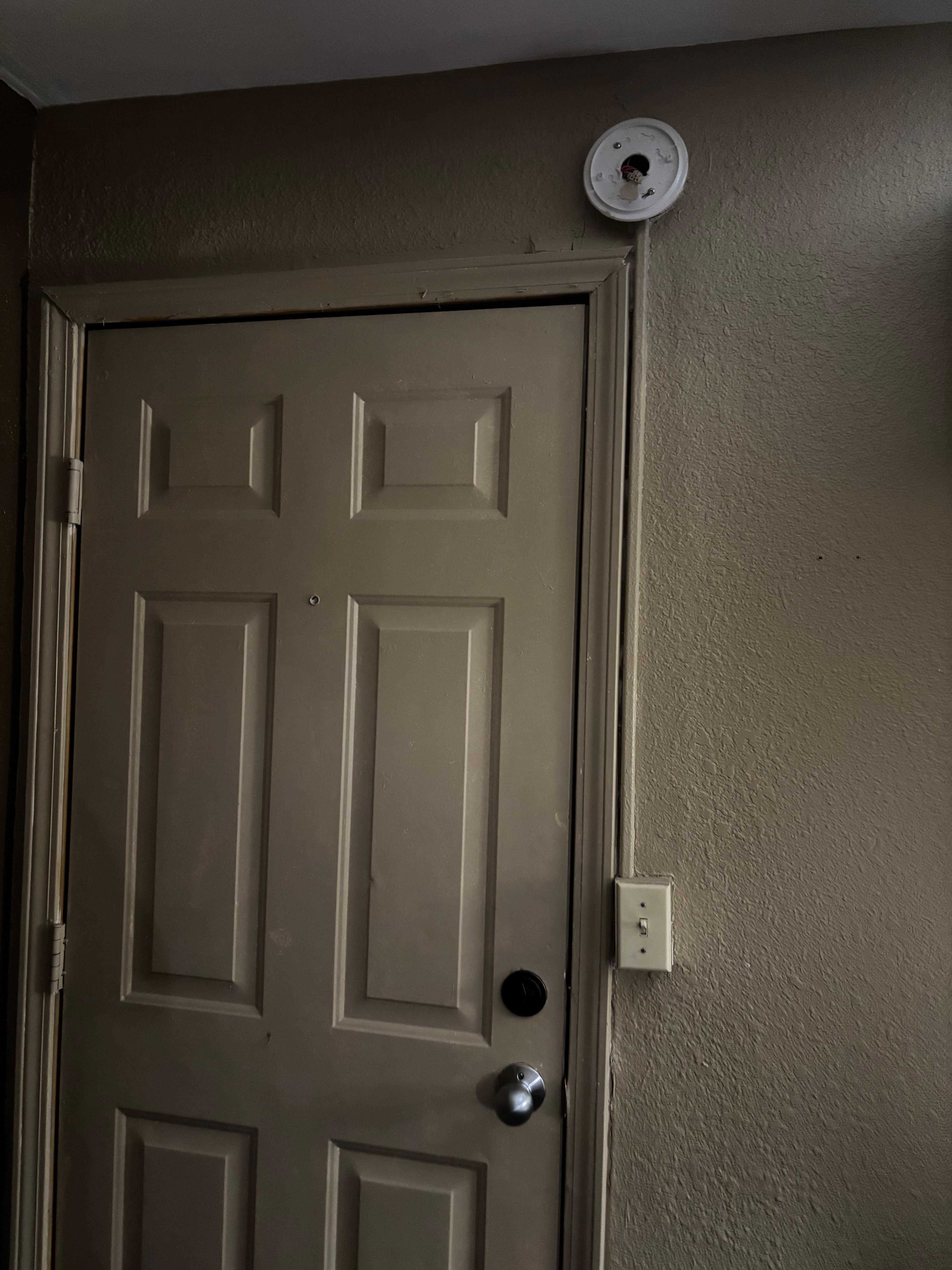 Smoke alarm taken apart and bent up door