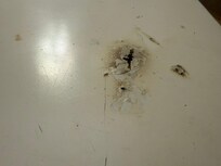 Cigarette burns on a table in a non-smoking room.