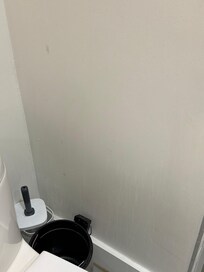 Urine splashed on the wall behind toilet