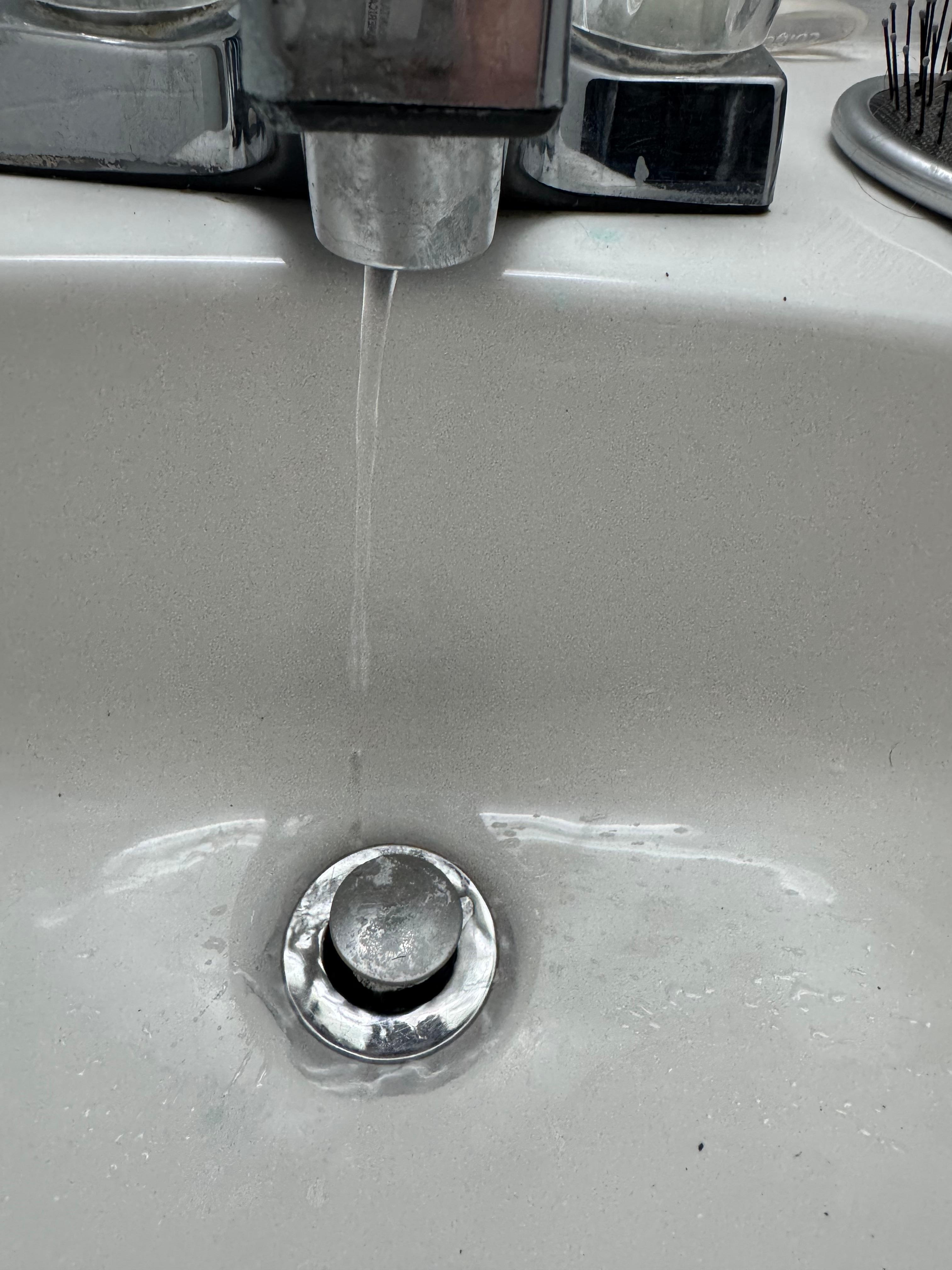 Drizzle of water in the bathroom sink