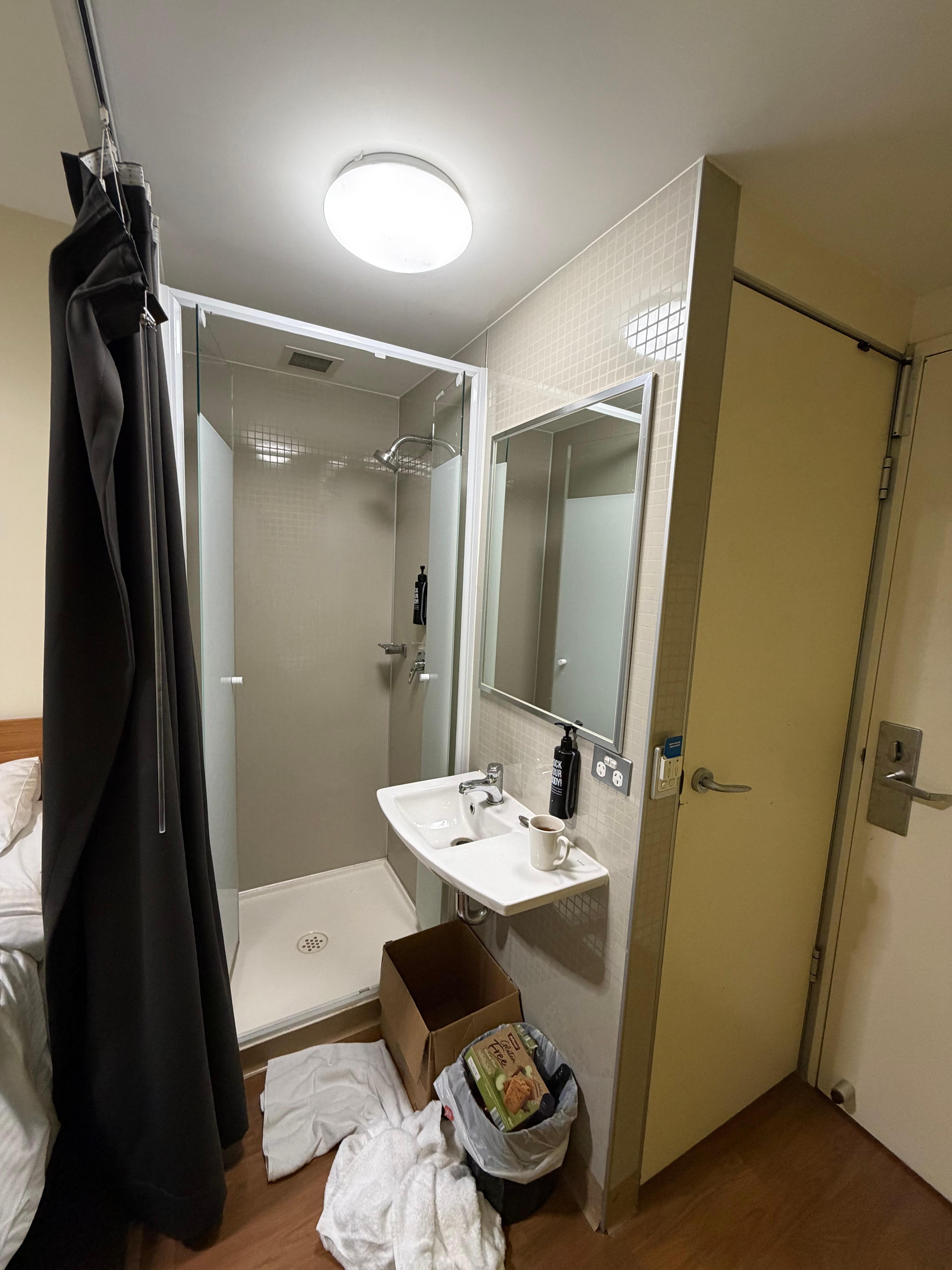The shower (no bathroom) with basin and toilet door.