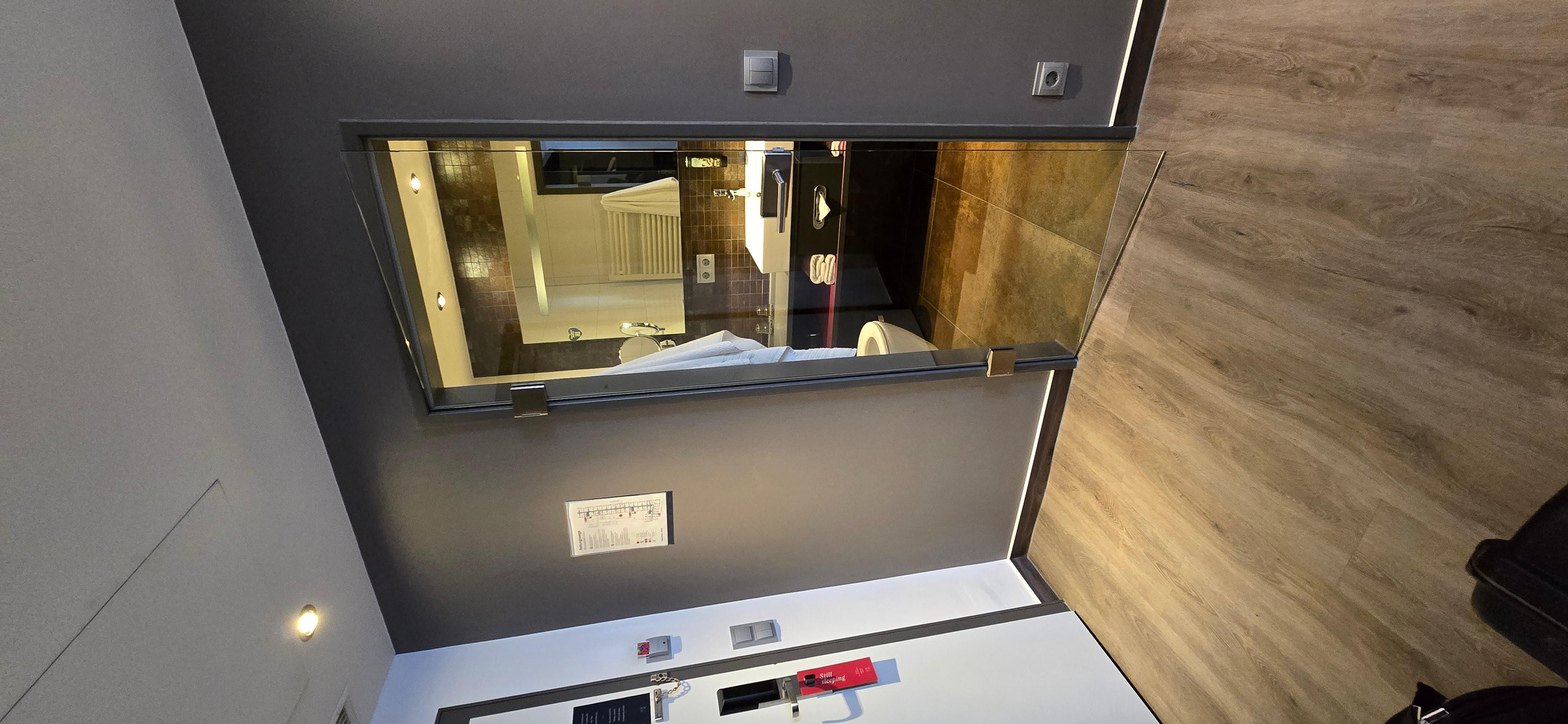 Veja a porta de vidro transparente tirando a privacidade do WC