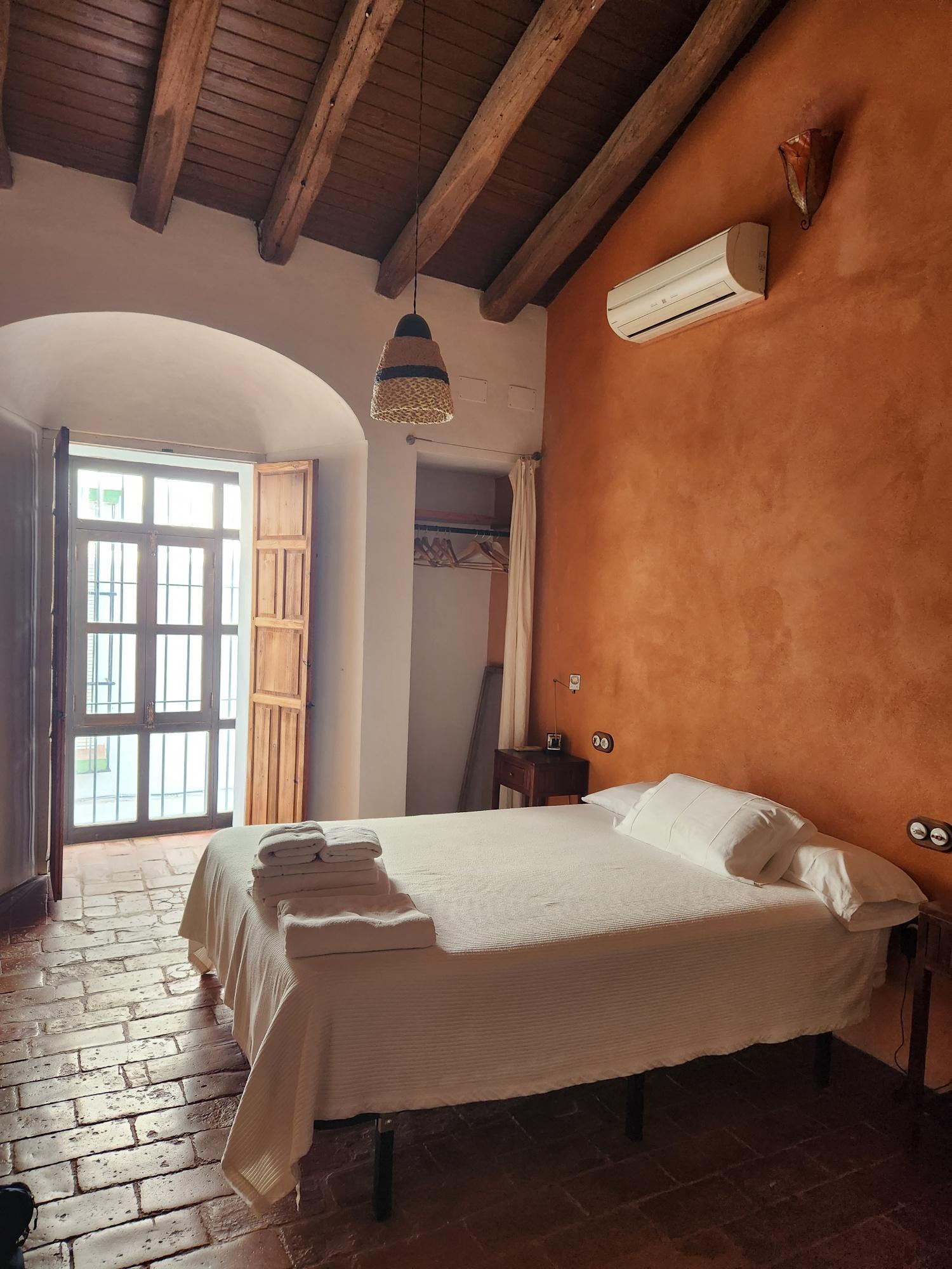 This bedroom faces the street and features a comfortable queen bed with Spanish wool blankets. We visited in April and left the windows open.