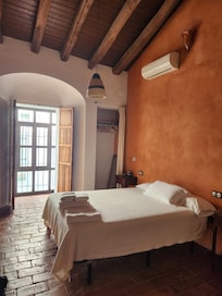 This bedroom faces the street and features a comfortable queen bed with Spanish wool blankets. We visited in April and left the windows open.