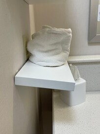 Shelf falling off bath wall.