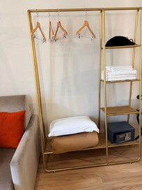 Open closet with a mini safe. Hair dryer is in the room.