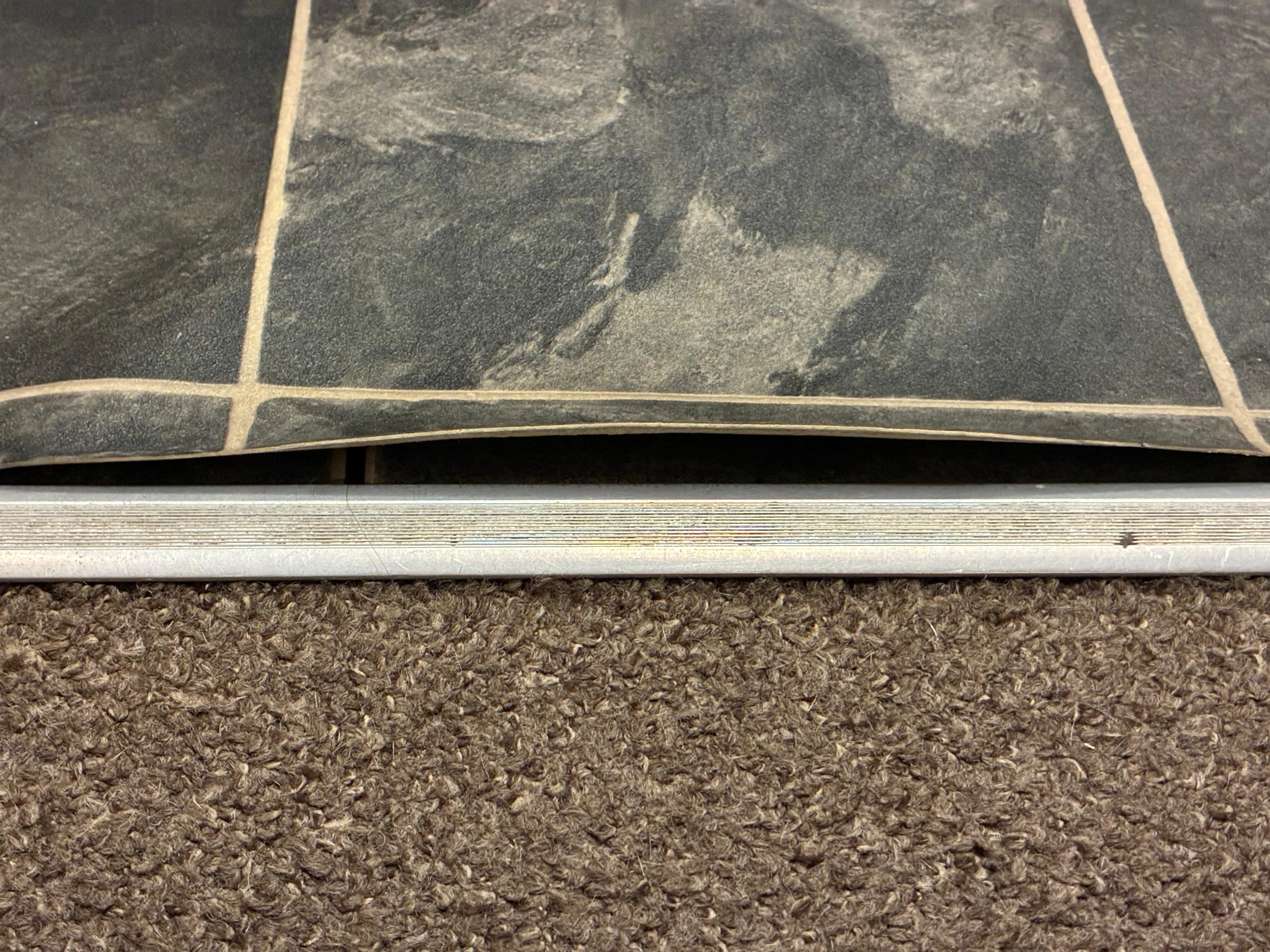 Linoleum flooring in bathroom, one inch buckling on entering room