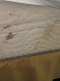 Zoom in, blood and dirt on mattress.