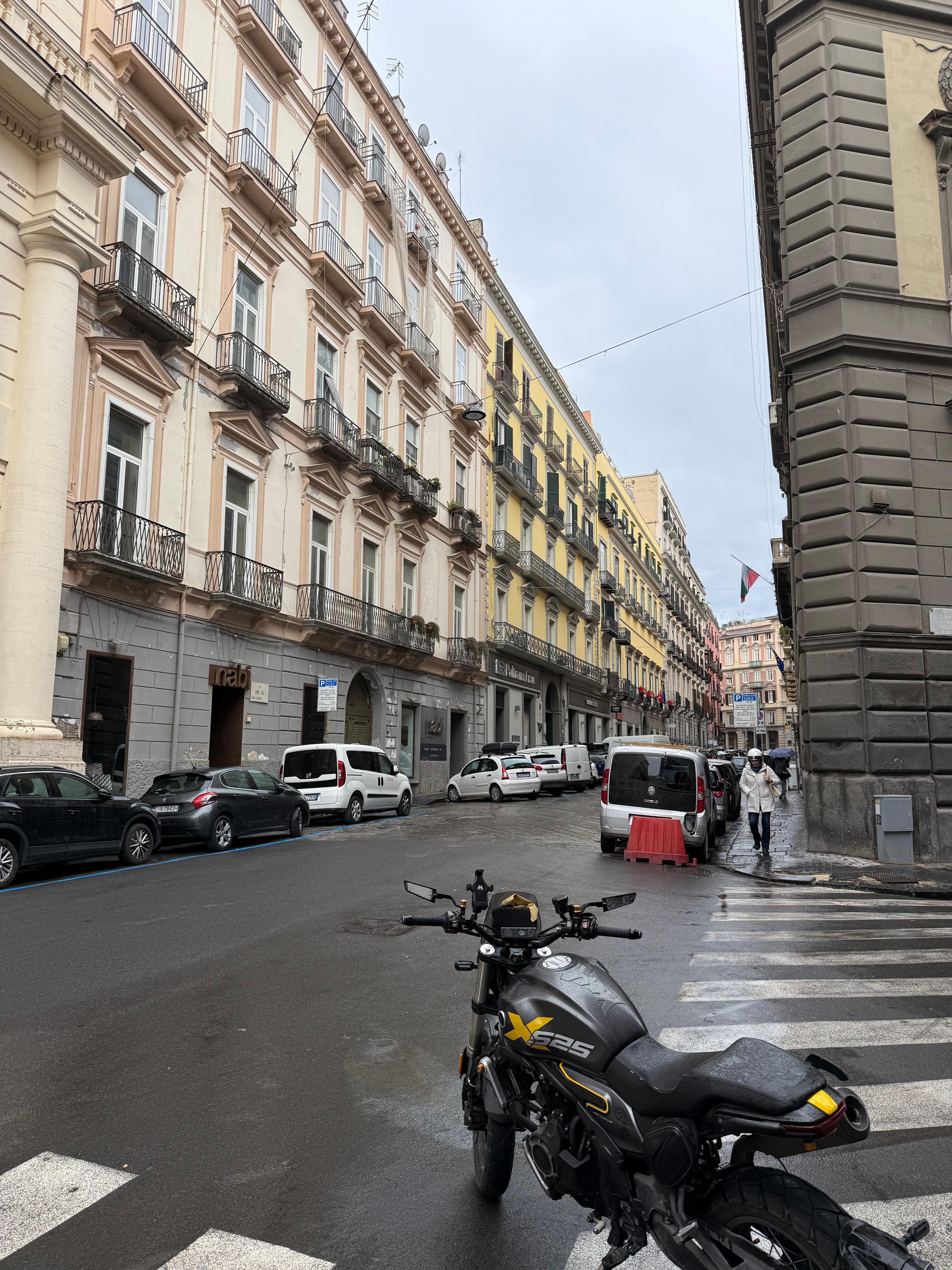 The hotel is the yellow building on the left, with a green door.