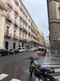 The hotel is the yellow building on the left, with a green door.