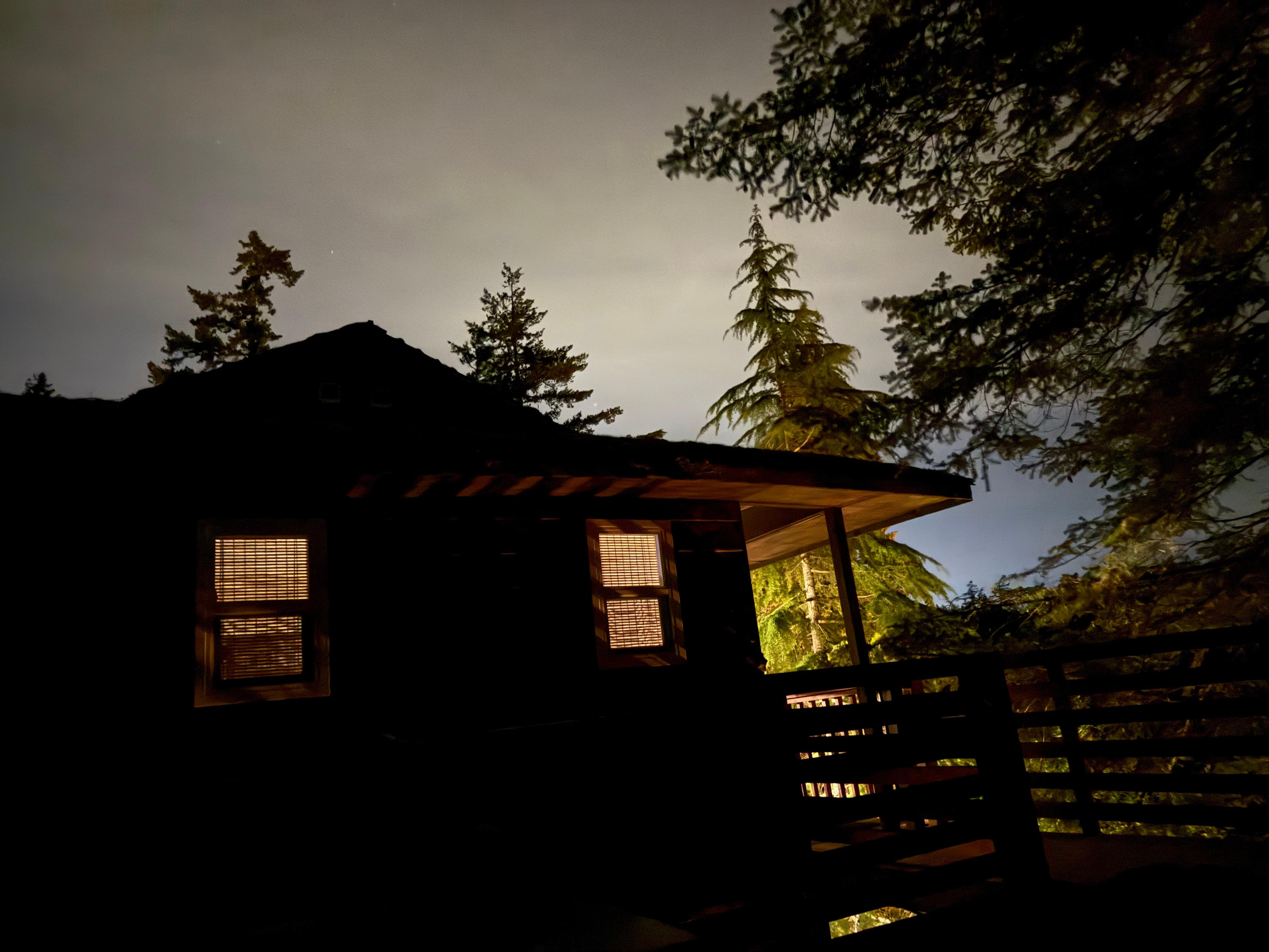 Late evening view of the house from the deck with the fire table and hot tub.