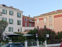The apartment is in the pink building on the right