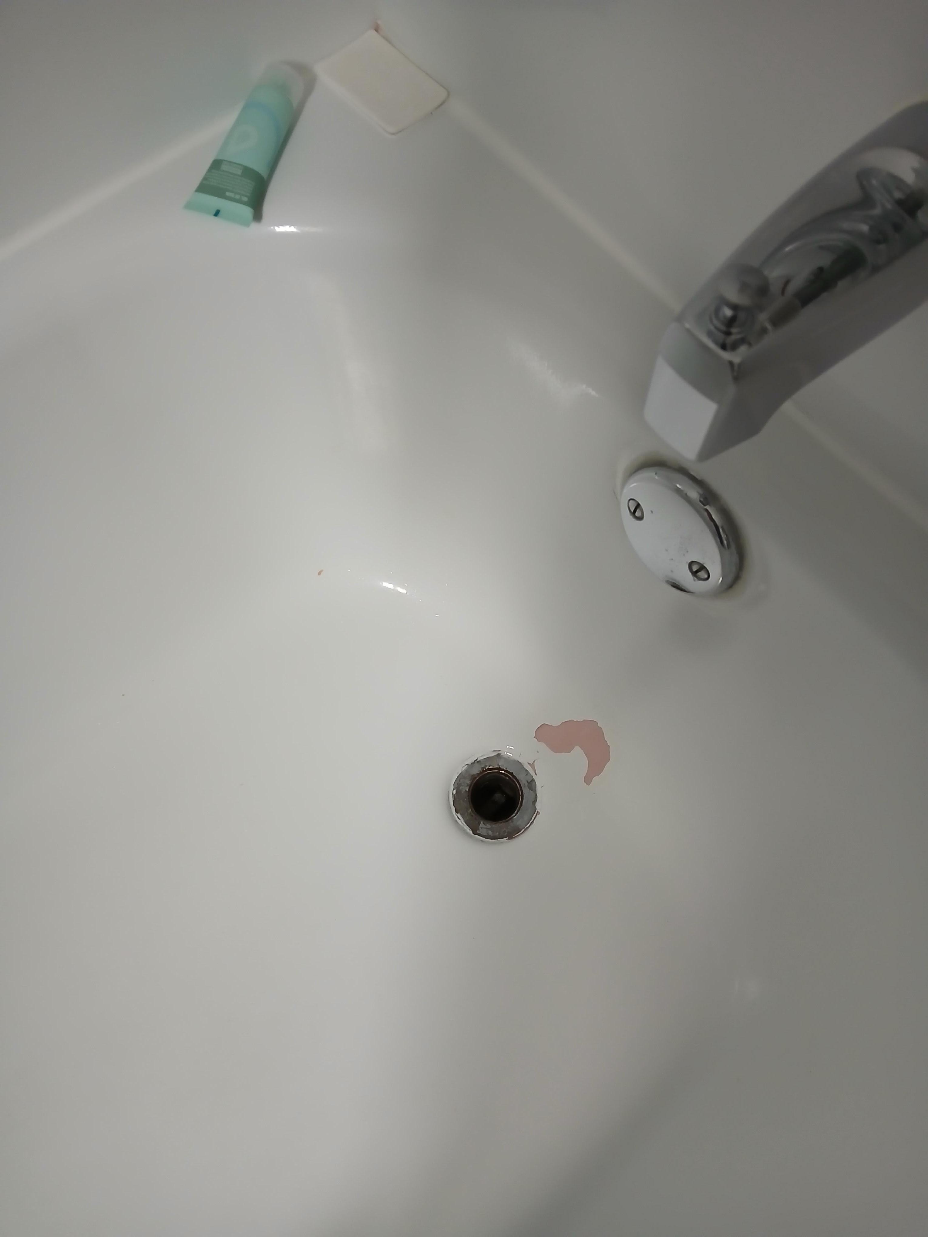 Tub was resurfaced long ago and is peeling.
