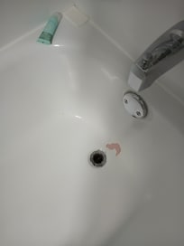 Tub was resurfaced long ago and is peeling.