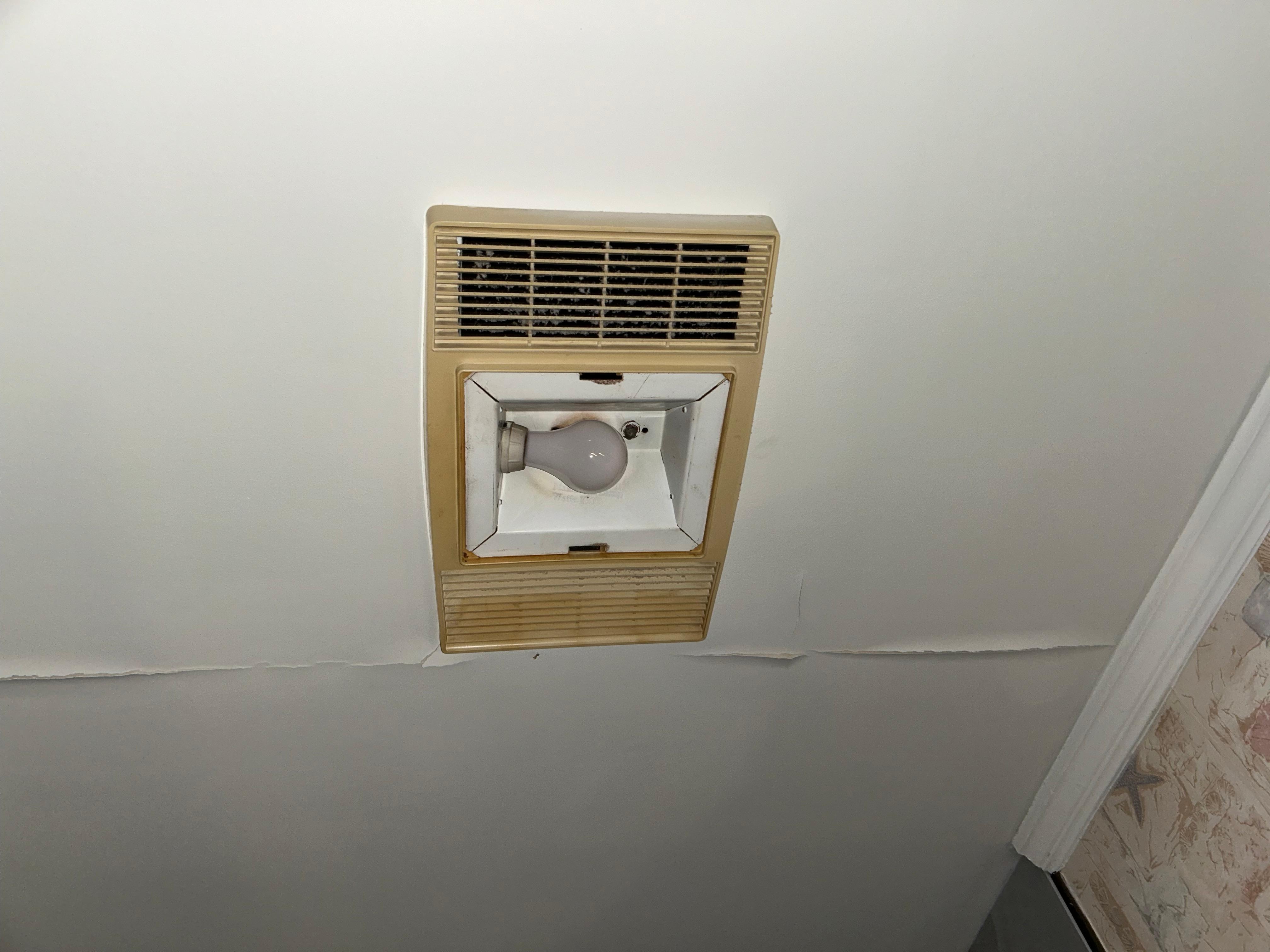 Cracks in bathroom ceilings with old brown looking fans 
