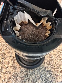Wet old coffee grounds in the maker upon arrival