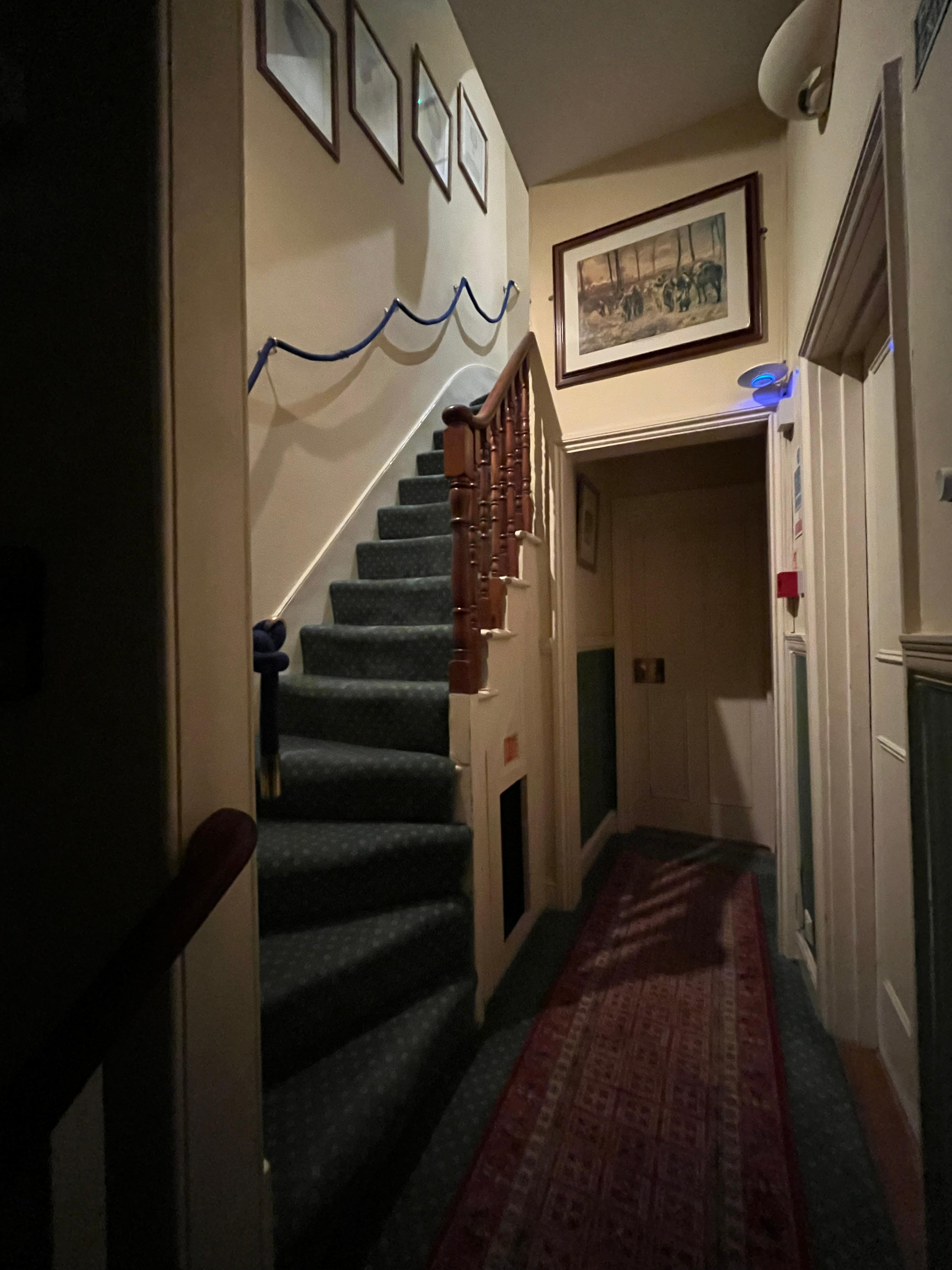 Stairs between second and third floors, with a rope to hold onto as you climb.