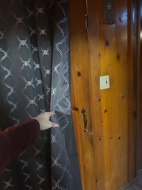 Inside the cabin, the door covered by a makeshift curtain